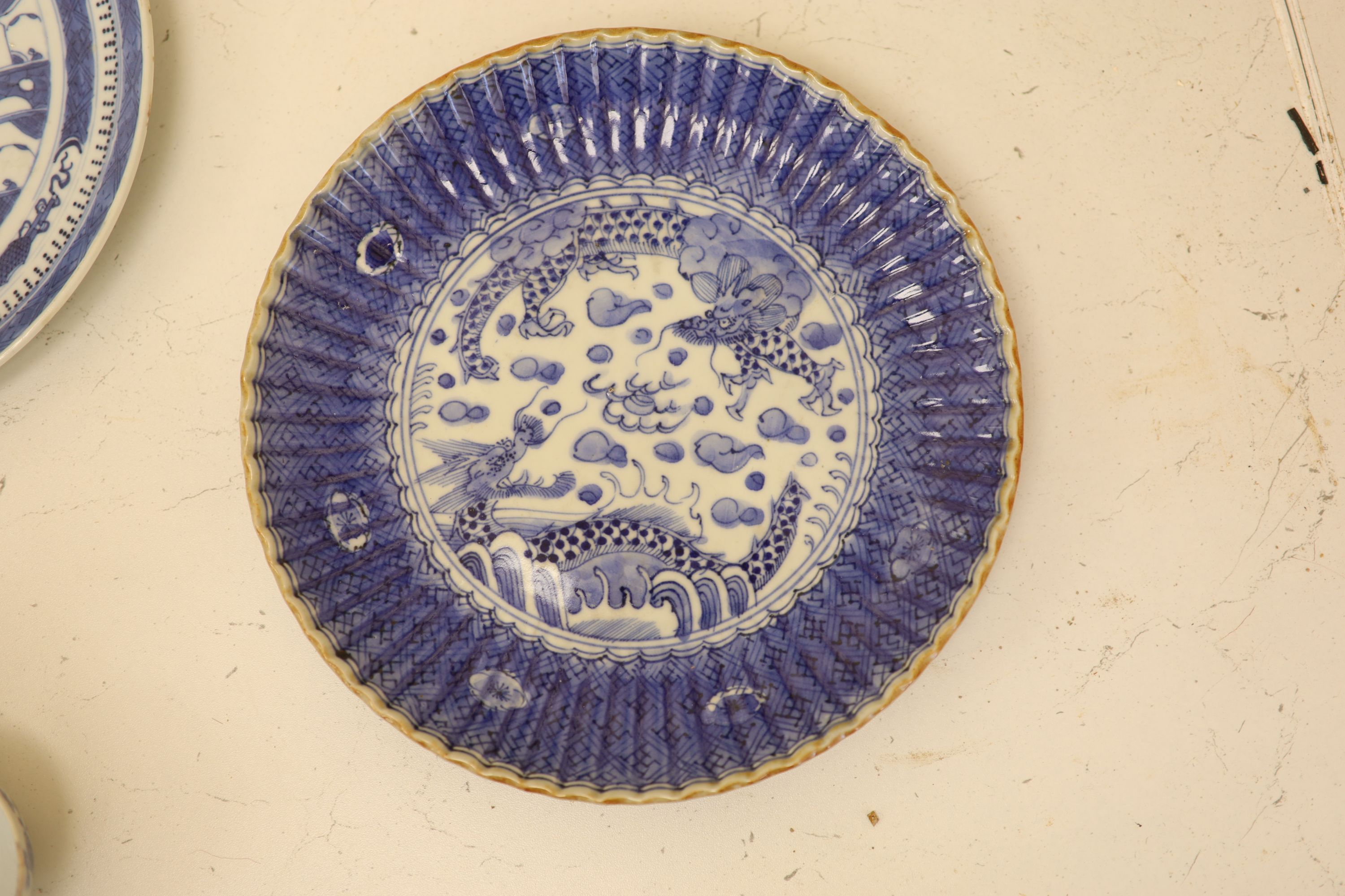 An 18th century Chinese blue and white mug and cup, a 19th century Chinese blue and white plate and a Japanese plate